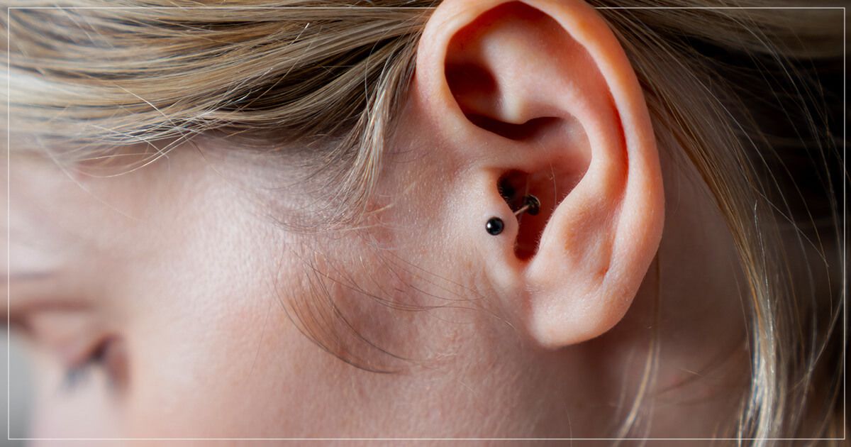 Side profile of a woman with tragus ear piercing.